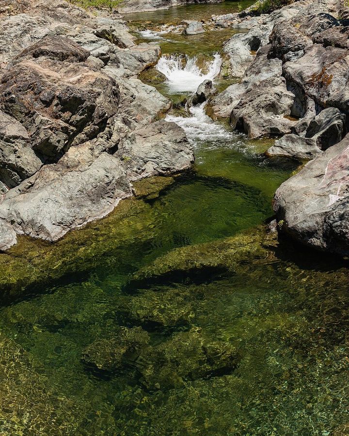 Água clara de rio de montanha correndo entre pedras